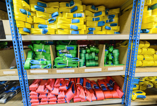Green, yellow and red nylon soft lifting slings stacked in piles.
