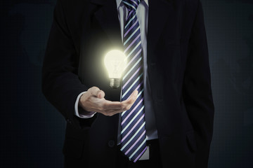 Businessperson holds bright lightbulb