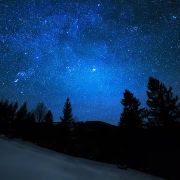 Milky Way in sky full of stars. Winter mountain landscape in night.