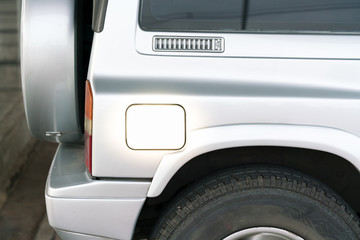 petrol cap cover of a silver car with copy space - fuel tank