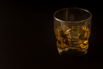 Glass of whiskey on a dark background