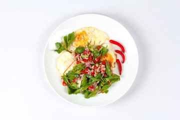 Thai food,Spicy wing bean with pork topped fried egg.
