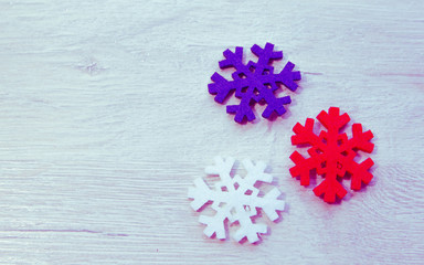 three snowflakes red white and blue on a wooden background, top view, space for text, as  carrier  Christmas