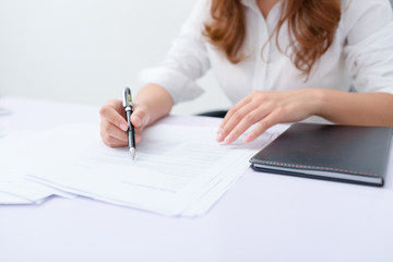 Business woman filling information on document.