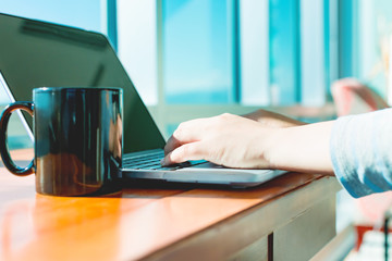 Fototapeta premium Woman working on a laptop in a bright room