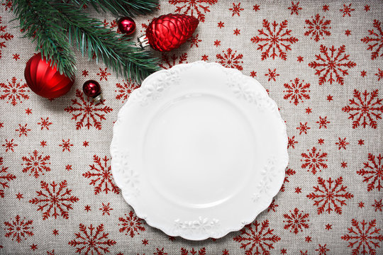 Vintage Christmas plate on holiday background with Red Christmas ornaments. Xmas card. Happy New Year. Space for text