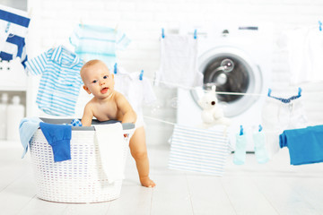 fun happy baby boy  to wash clothes and laughs in laundry