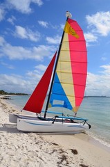 Small sailing catamaran available for rent resting in the sand at a beach on Key Biscayne ,Florida