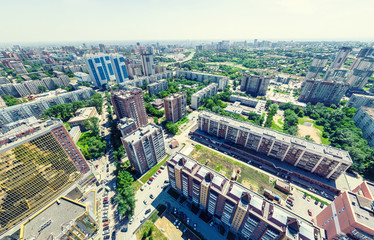 Fototapeta premium Aerial city view with crossroads and roads, houses, buildings, parks and parking lots, bridges. Urban landscape. Copter shot. Panoramic image.