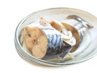 Salted fish mackerel with spice on a plate, white background