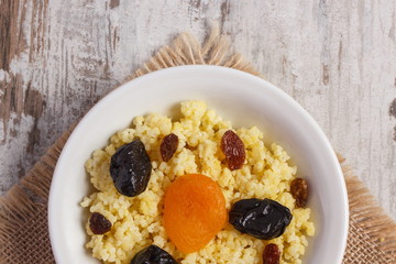 Cooked millet groats on white plate, healthy food and nutrition