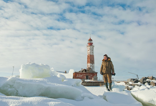 Winter Lighthouse. fisherman on The Lighthouse island in the winter on the Ladoga Lake. Suho Island. Russia.