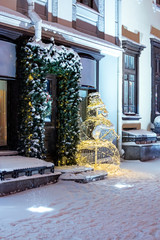 holiday decorations with snowman and christmas lights on night street of winter city