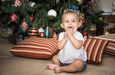 baby with mum sitting near Christmas tree in the house