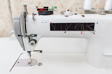 Sewing machine with colorful needles side view. Professional equipment of seamstress. Tailor workshop, garment factory, clothes making industry concept