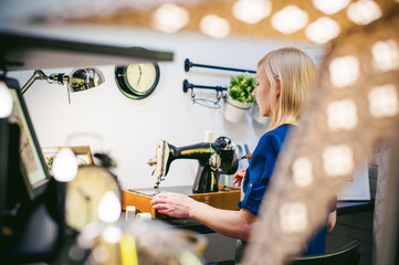 seamstress work on the sewing machine. young blonde woman workin