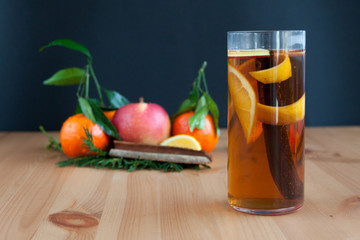 Glass with Seasonal warming drink.Cinnamon,lemon zest and some fruits.