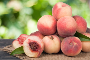 heap of peaches on a wooden table with blurred background