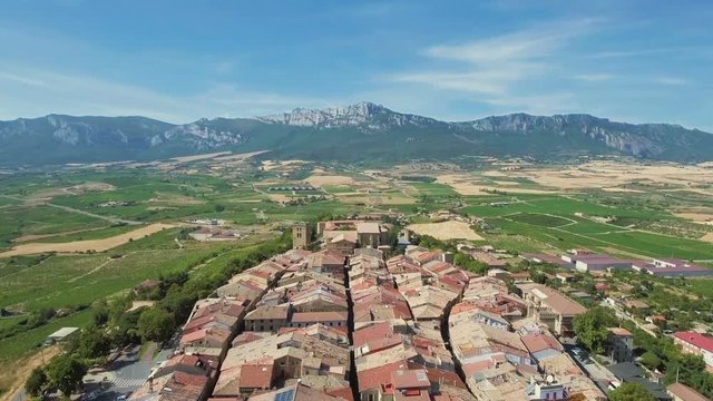Flying over Laguardia Old Town with vineyards and mountains on the horizon, Spain