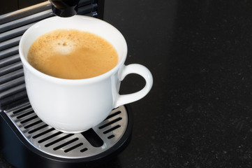 Freshly brewed creamy coffee from espresso machine.