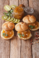 Sweet sandwiches with butter, marmalade kiwi, mint and peanuts close-up. vertical