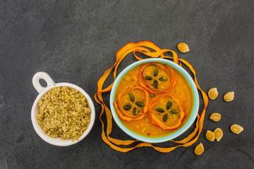 Tasty pumpkin soup and quinoa grains in bowl on stone background. Vegetarian food. 