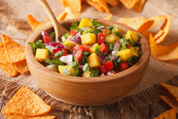Mexican cuisine: salsa with mango, pepper, cilantro and onion closeup in a bowl and corn chips. horizontal