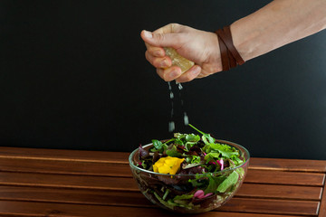 Glass bowl filled with organic superfood salad with flowers.Men