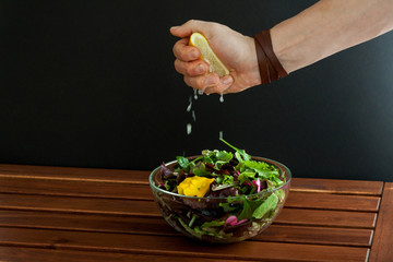 Glass bowl filled with organic superfood salad with flowers.Men