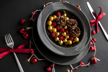 Christmas Decorations in the black plate with fork and knife on