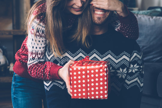 Woman giving Christmas gift to beloved