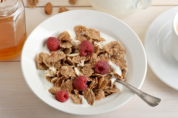 cereal with raspberries and almonds and rice flakes and milk in