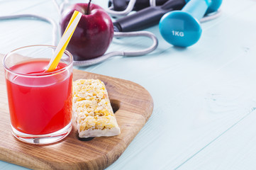The concept of weight loss, jump rope, juice, cereal bar and red apple. Healthy lifestyle. Fitness Background. Sport and diet.