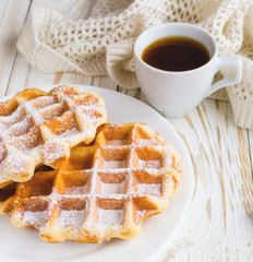 Warm knitted plaid, cup of coffee and Belgium waffles