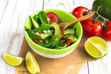 Green salad with avocado, tomatoes, spinach, lime and spices