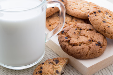 Transparent cup with milk and oatmeal cookies