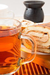 Transparent cup of hot tea and chocolate cake