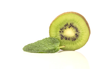Obraz na płótnie Canvas one piece of the cut sweet ripe kiwi with mint leaves