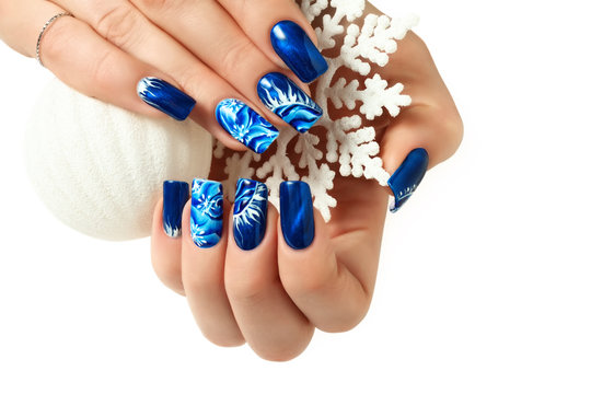 Female hands with New Year design on the nails holding snowflake.Isolated.