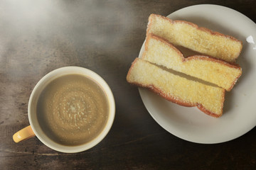Coffee and bread at relaxation time on wooden table in morning.selective focus.