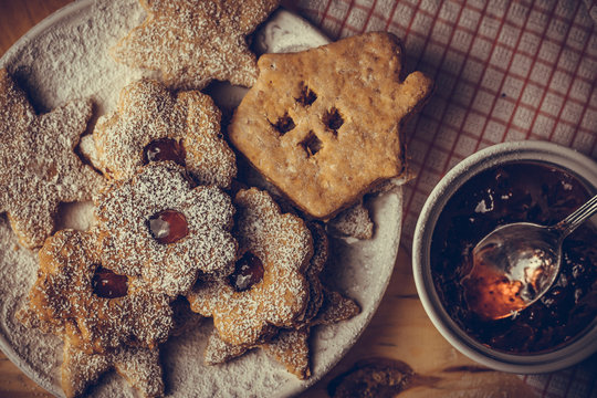Homemade Christmas gingerbread and linzer cookies with jam, powdered, top flat view, soft haze effect, vintage