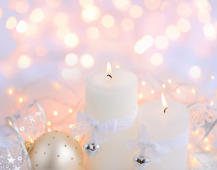 Christmas candles on the snow and Christmas lights. Festive Christmas background