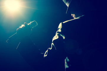 Songer hand holding the microphone with spot light and len flare