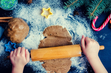 Young girl's hands sheeting dough with rolling pin