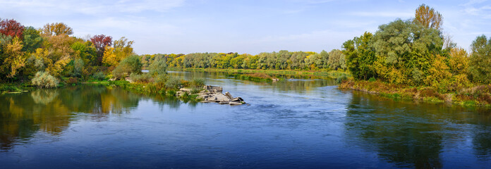 Fototapeta na wymiar Panoramic views of the river. Autumn forest on the bank. A clear