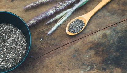 Chia seed in black bowl on wooden table - split toning effect