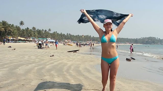 Happy young woman walking on the beach