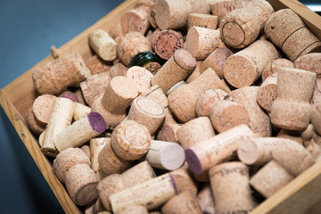 Heap of used wine corks in a wooden box