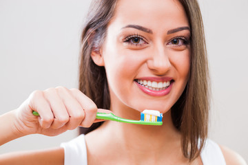 Young woman holding toothbrush. Dental hygiene concept. 