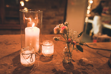 Windlichter und Blumenschmuck auf rustikalem Holztisch
